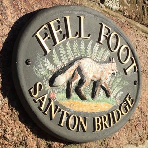 Sign on the side of a house featuring a fox and the words "Fell Foot - Santon Bridge"